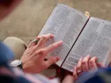 Hände halten eine Bibel. Eine Frage ist, ob Jesus Gott ist.