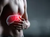 Mężczyzna trzyma się za brzuch, gdzie widoczna jest czerwona, świecąca wątroba z naczyniakiem.