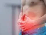 Homme tenant son ventre, zone rouge indiquant une douleur, possible déchireure abdominaux.