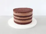 Czekoladowy naked cake z kremem, warstwy biszkoptu i kremu czekoladowego.