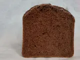 Kawałek ciemnego, puszystego chleba czekoladowego z widocznymi porami. Idealny na słodkie śniadanie.