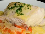 Cogote de merluza jugoso y tierno, servido sobre patatas y tomate, con un toque de perejil fresco.