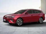 Czerwony MG5 Electric, kombi, stoi na betonowym placu z widokiem na morze.