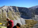 Escursionisti con zaini rossi ammirano il panorama montuoso vicino al bivacco Fusco.