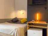 Przytulny pokój z łóżkiem, ozdobną lampą i lodówką. Idealne miejsce na **weekend w Karpaczu**.