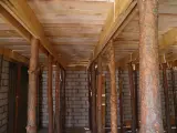 Szalowanie stropu z drewnianymi stemplami, tworzącymi rusztowanie pod przyszły strop.