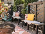 A cozy patio with a diy privacy screen, fire pit, and colorful chairs.