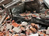 Zniszczony budynek z cegłami i betonem. To pokazuje, że gruz nie nadaje się do wyrzucania do zwykłych śmieci.