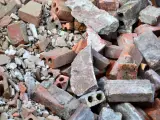 Stos gruzu budowlanego, cegieł i betonowych fragmentów. To materiał, który może być zaklasyfikowany jako gruz kod odpadu.