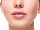 Primo piano di labbra carnose e rosa, con un leggero lucido, che mostrano diversi tipi di labbra.