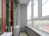 Wnętrze loggii z widokiem na miasto. Drewniane drzwi i okna wychodzą na zewnątrz.