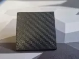 A small cube with a textured surface, showcasing the intricate pattern achieved through carbon fiber 3D printing.