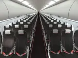 Wnętrze samolotu linii lotniczych ITAKA. Rzędy czarnych foteli z czerwonymi przeszyciami i białymi zagłówkami z logo ITAKA.