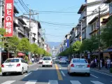 Jaki ruch jest w Japonii? Ulica w Kioto z samochodami, pieszymi i tradycyjną architekturą.