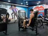 Man tränar ben på en **floor press**-maskin i ett modernt gym.