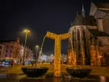 Złota fontanna w centrum miasta, obok zabytkowego kościoła. Wieczorne Pilzno, pełne urokliwych atrakcji.