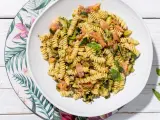 Un piatto invitante di pasta fredda con zucchine e salmone, condita con basilico fresco. Perfetta per un pasto estivo leggero e gustoso.