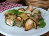 Deliziosi involtini di zucchine con salmone e formaggio, guarniti con menta fresca.