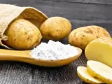 Kartoffeln und ein Löffel voller Kartoffelstärke, eine vielseitige kartoffelmehl alternative für Küche und Haushalt.