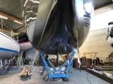 Schwarzer Rumpf einer Yacht im Trockendock, bereit, das Antifouling zu erneuern.
