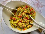 Kolorowa sałatka z kaszą bulgur, pomidorami, ogórkiem i ziołami, gotowa do podania.