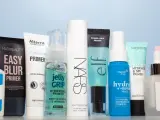 Eine Reihe von Make-up-Primern in verschiedenen Größen und Marken, auf hellblauem Hintergrund.