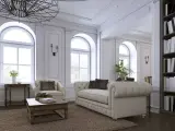 Elegancki salon z sofą, fotelem i książkami na półce.