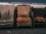 Trzy zniszczone fotele, które wyglądają, jakby czekały na to, gdzie wywieźć stare meble.