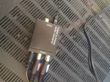 Konwerter cyfrowo-analogowy audio z podłączonymi kablami RCA i optycznym.