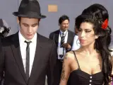 Blake Fielder-Civil w czarnym garniturze i kapeluszu obok Amy Winehouse z czerwoną różą we włosach.