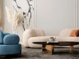 Un divano beige dalle forme morbide crea un'atmosfera accogliente, con abbinamenti di cuscini in terracotta e blu.