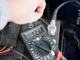 Sprawdzanie prawidłowego napięcia akumulatora multimetrem. Wynik 12.6V wskazuje na dobry stan.