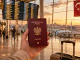 Polski paszport w dłoni na tle lotniska z turecką flagą. Czy Turcja jest w UE? Podróż do kraju poza Unią Europejską.