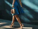 Złote szpilki i torebka to idealne dodatki do niebieskiej sukienki, tworząc elegancki look.