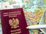 Paszport tymczasowy Rzeczypospolitej Polskiej, polskie banknoty i model samolotu na tle mapy Europy.