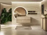 Une **salle de bain chic et cosy** avec un meuble vasque en bois clair, un grand miroir rond lumineux, des plantes luxuriantes et une ambiance apaisante.