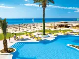 Słoneczny dzień na plaży w Tunezji. Basen, palmy i leżaki zapraszają do relaksu.