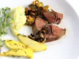 Rehleber zubereiten: zarte Scheiben Rehleber mit gebratenen Zwiebeln, Kartoffelpüree, gebratenen Kartoffelspalten und frischen Kräutern auf einem weißen Teller.