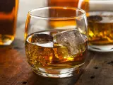 Szklanka złocistego trunku z lodem, obok butelki. Dylemat: whisky szkocka czy irlandzka?