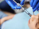 Dentysta podaje znieczulenie miejscowe pacjentowi.