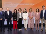 Presentación del código de ética de una empresa. Un grupo de siete profesionales posa en un escenario con un fondo naranja y blanco.