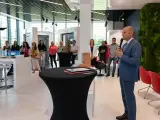 Mężczyzna w garniturze przemawia do grupy osób w nowoczesnym salonie okien i drzwi.