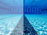 Underwater view of a swimming pool, half clear and half cloudy, with lane lines and lane markers.