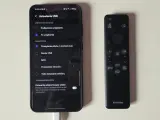 Telefon podłączony do telewizora przez USB. Ustawienia USB na ekranie telefonu pokazują opcje przesyłania plików, co jest kluczowe, jak połączyć telefon z telewizorem.