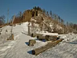 Śnieżna ścieżka prowadzi na szczyt Nosala, gdzie leżą powalone pnie drzew.