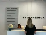 Recepcja gabinetu stomatologicznego Primamedica z tablicą informacyjną i pracownicą.