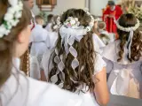 Dzieci w białych strojach, z wiankami na głowach, czekają na swoją pierwszą komunię. Wzruszający moment w kościele.