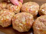 Mani che preparano polpette in bianco, un impasto di carne macinata con verdure, pronte per essere cucinate.