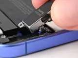 Dłoń wyjmuje moduł Taptic Engine z wnętrza telefonu, element odpowiedzialny za zaawansowane wibracje i 3D Touch.