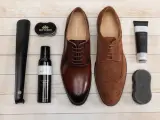 Zestaw do pielęgnacji obuwia: eleganckie brązowe i zamszowe buty, łyżka do butów, pianka czyszcząca, krem wodoodporny i gąbka. Idealny poradnik, jak pastować buty.
